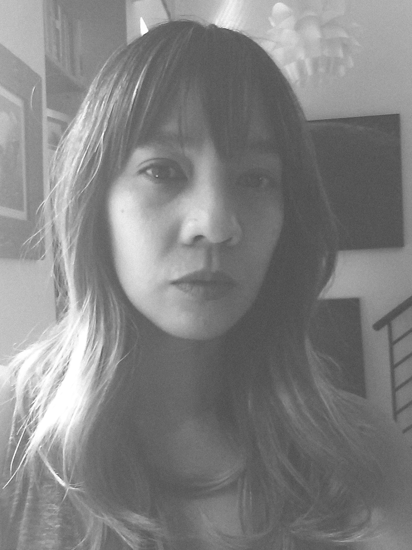 Dao is centered in a portrait-orientation photograph rendered in greyscale. She is seen from the shoulders up, looking at the camera.