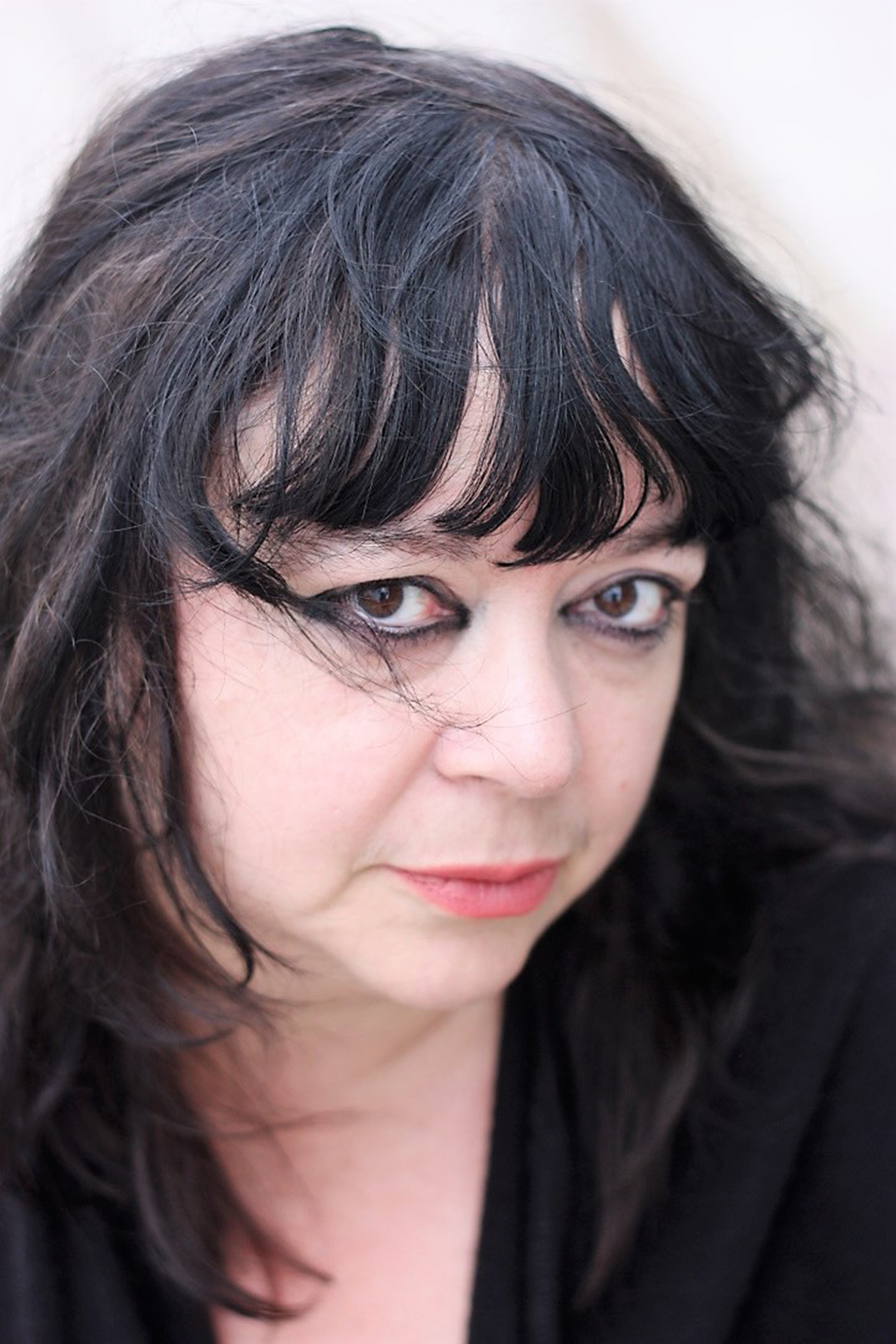 Diane Seuss is wearing red lipstick and thick black eyeliner, looking into the camera