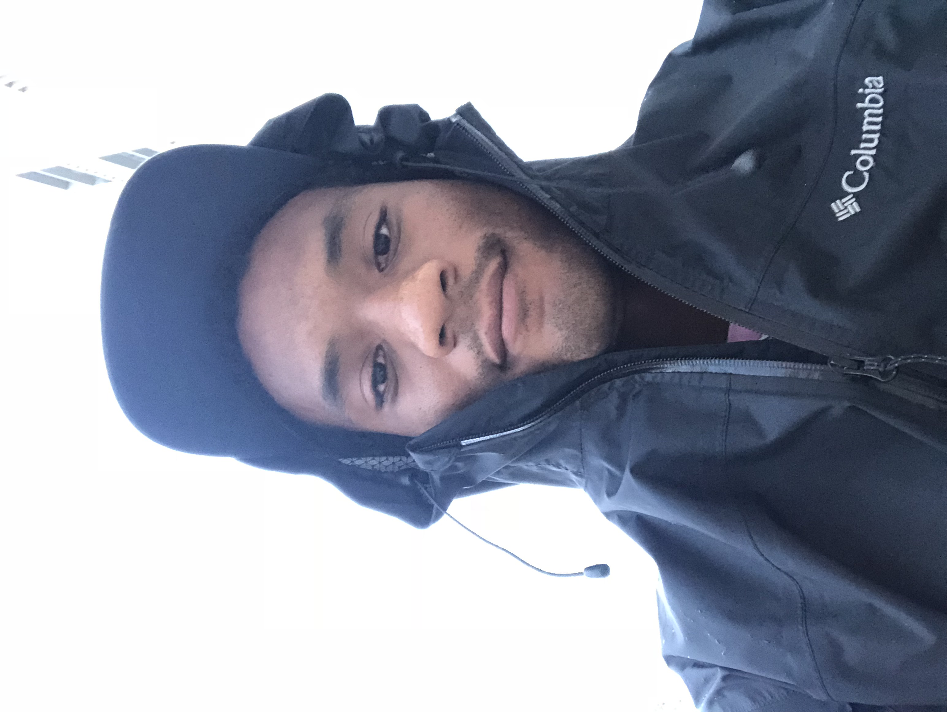 Kamden Ishmael Hilliard is looking at the camera wearing a black jacket and cap.