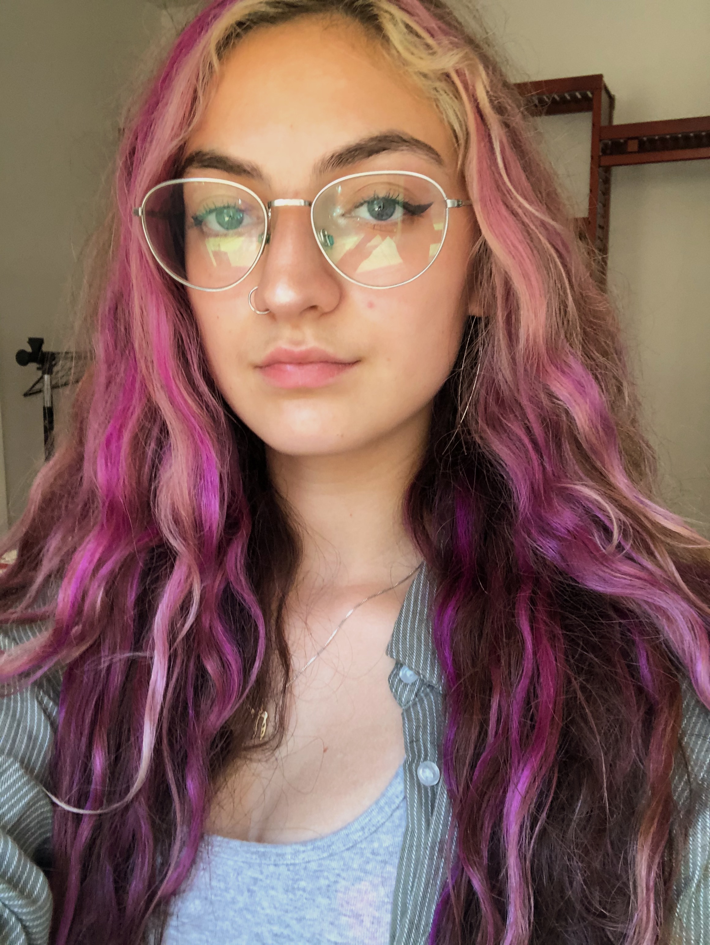 Sophia DuRose is facing the camera, wearing round glasses